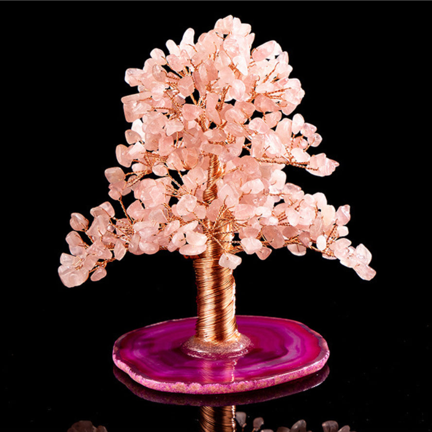 Arbre de vie décoratif en quartz rose et agate, avec un tronc torsadé en fil de cuivre rose et une base en agate violette, sur fond noir.