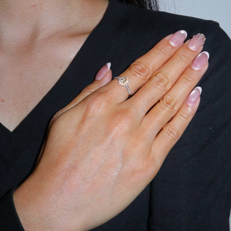 Bague en argent 925 avec une aigue-marine centrale en forme de fleur, portée au doigt d'une femme.