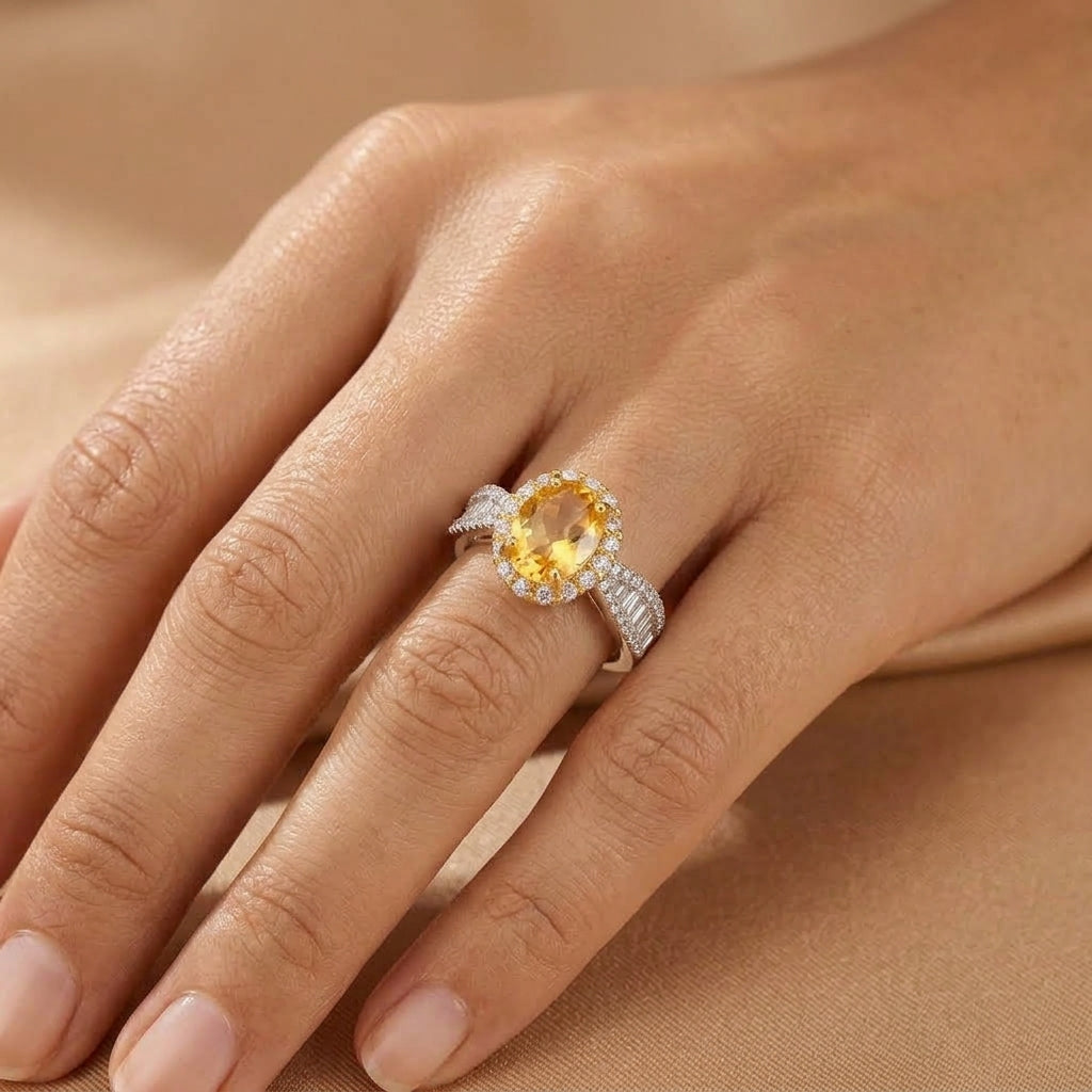 Bague Caresse Solaire en argent avec une citrine ovale centrale entourée de petits zircons brillants portée au doigt