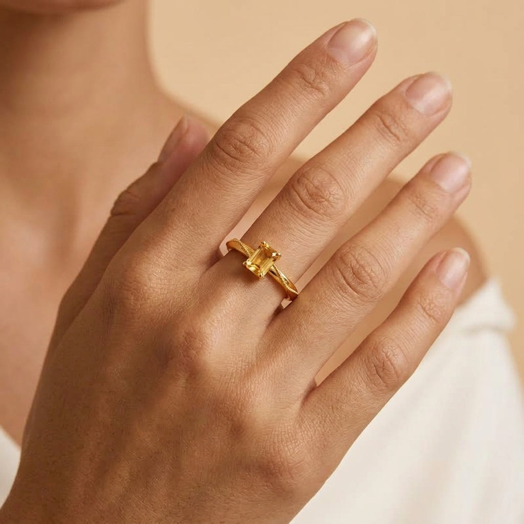 Bague Murmure Doré en argent plaqué or ornée d'une pierre fine citrine rectangulaire portée sur le doigt d'une femme
