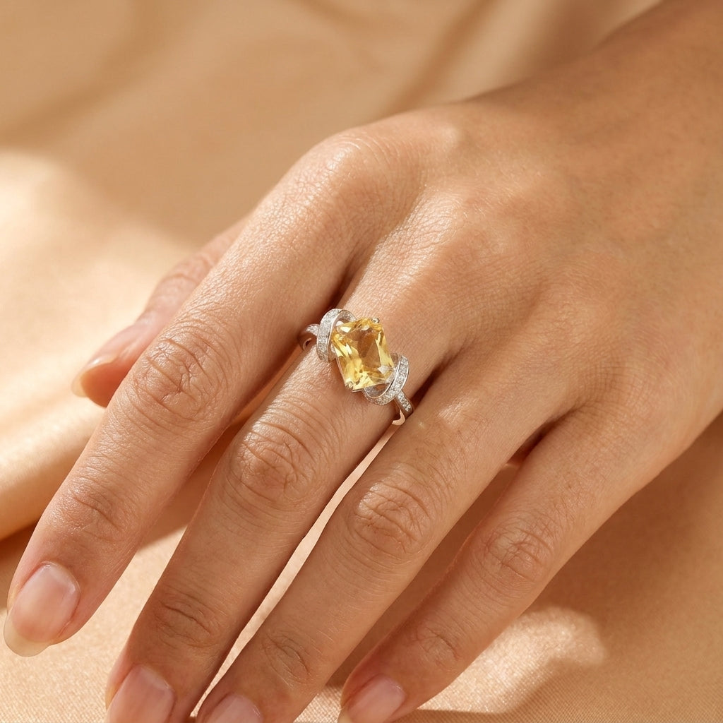 Bague Secret de Lumière en argent avec une pierre citrine rectangulaire portée sur le doigt d'une main féminine