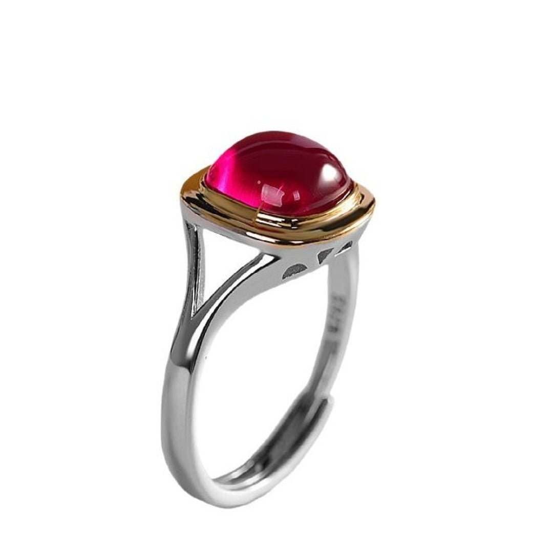 Bague ajustable en argent sterling 925 sertie d'une pierre de cornaline rouge vif de forme cabochon, avec une monture dorée moderne.