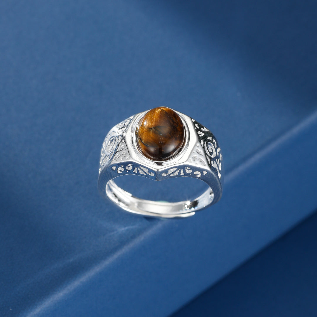 Bague ajustable pour homme ornée d'une pierre d'œil de tigre marron et d'une monture en argent aux motifs gravés.