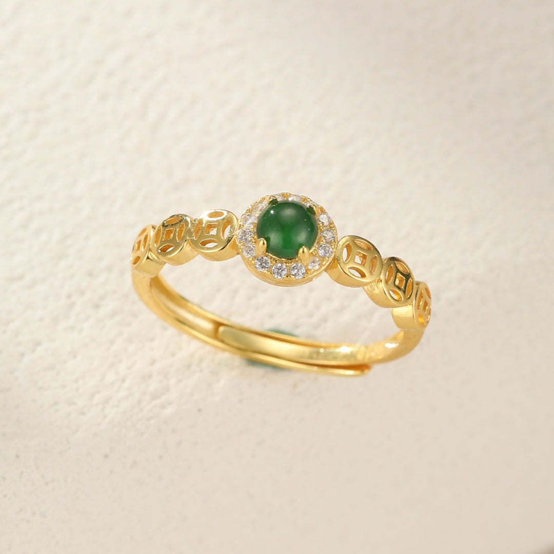 Bague ajustable en argent plaqué or, sertie d'une pierre de jade verte ronde entourée de zirconiums blancs, avec des motifs de pièces de monnaie anciennes sur l'anneau.