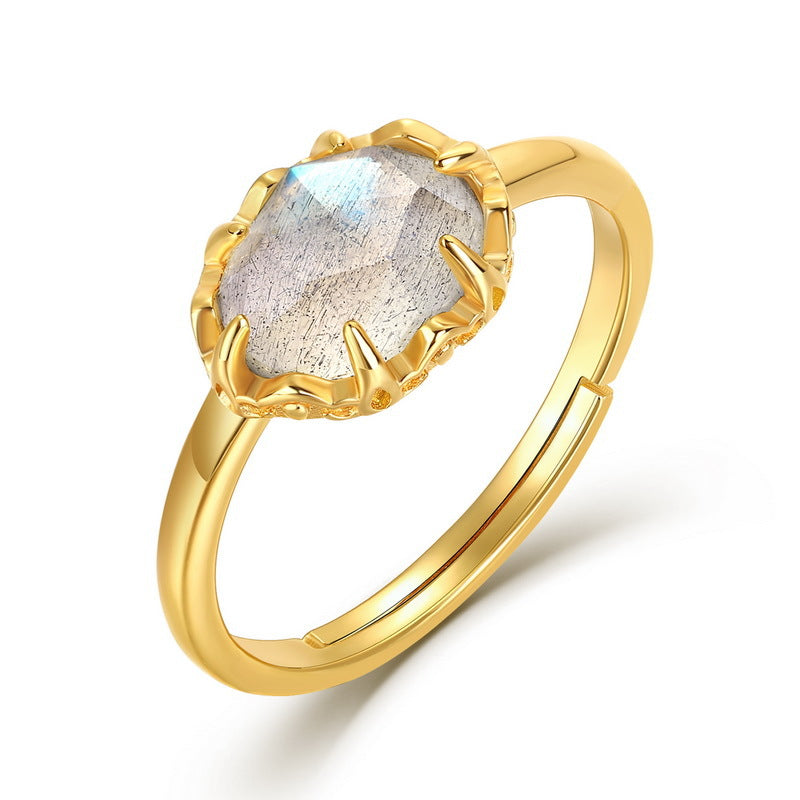 Bague ajustable en argent plaqué or sertie d'une labradorite ovale aux reflets bleutés et gris, avec une monture travaillée.