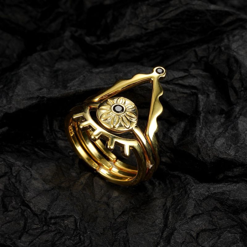 Bague triptyque en argent plaqué or ornée d'un œil stylisé avec une pierre noire centrale et des détails de triangle.