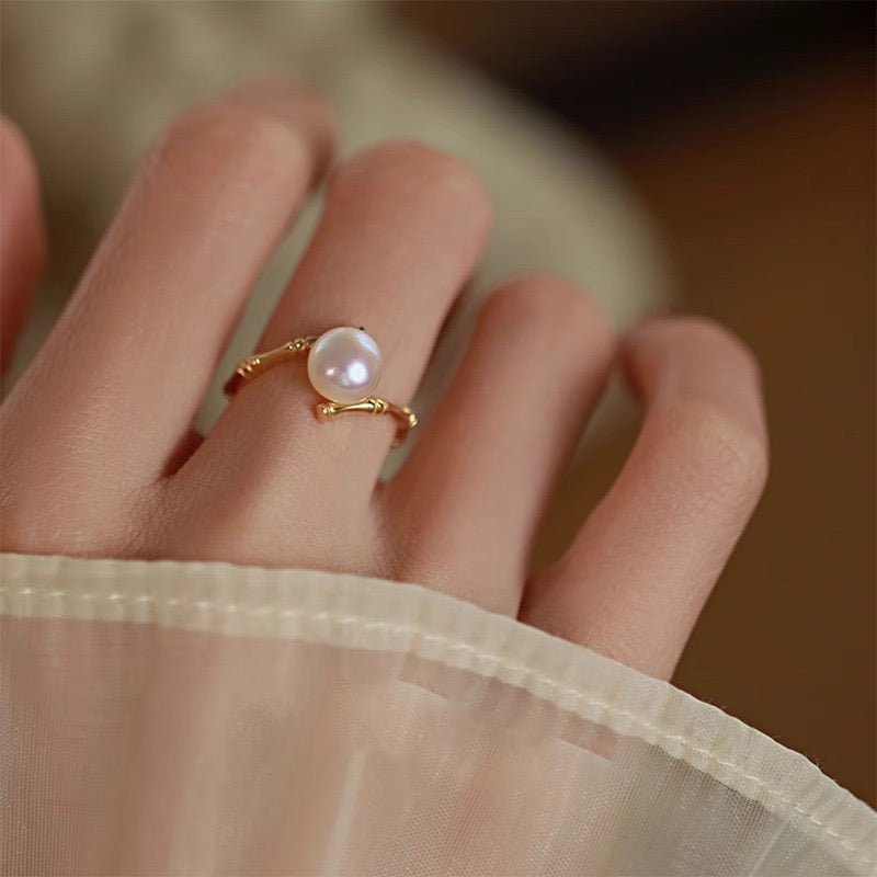 Bague en argent plaqué or avec une perle ronde et un design inspiré du bambou.
