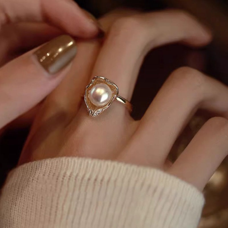 Bague en argent plaqué or sertie d'une perle nacrée et de petits cristaux, design unique rappelant une coquille.