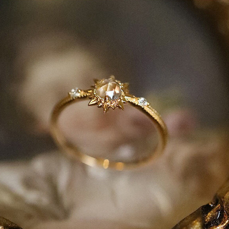 Bague en argent plaqué or ornée d'un quartz clair taillé en forme de soleil, sertie de petits diamants de chaque côté.