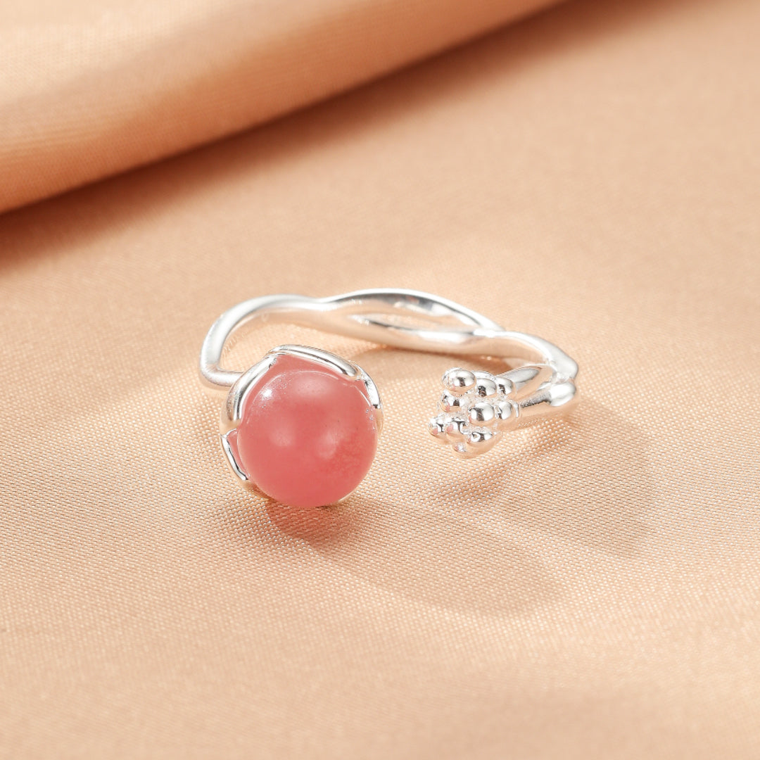 Bague ouverte en argent 925 avec une pierre de quartz rose ronde, design de fleur délicate.