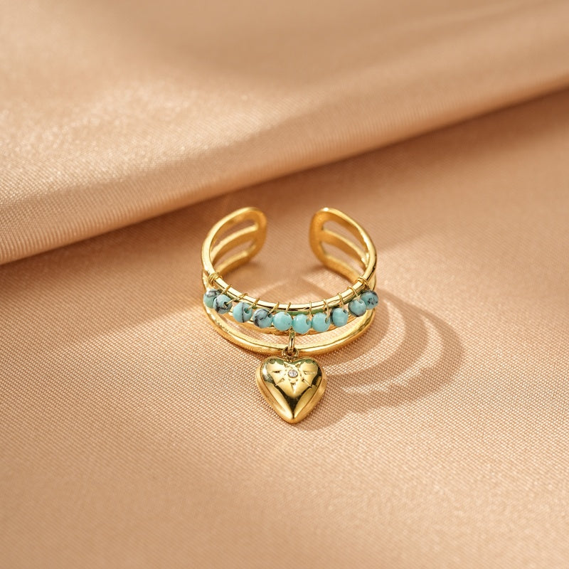 Bague turquoise réglable en acier inoxydable doré avec un pendentif cœur et des petites pierres bleues.