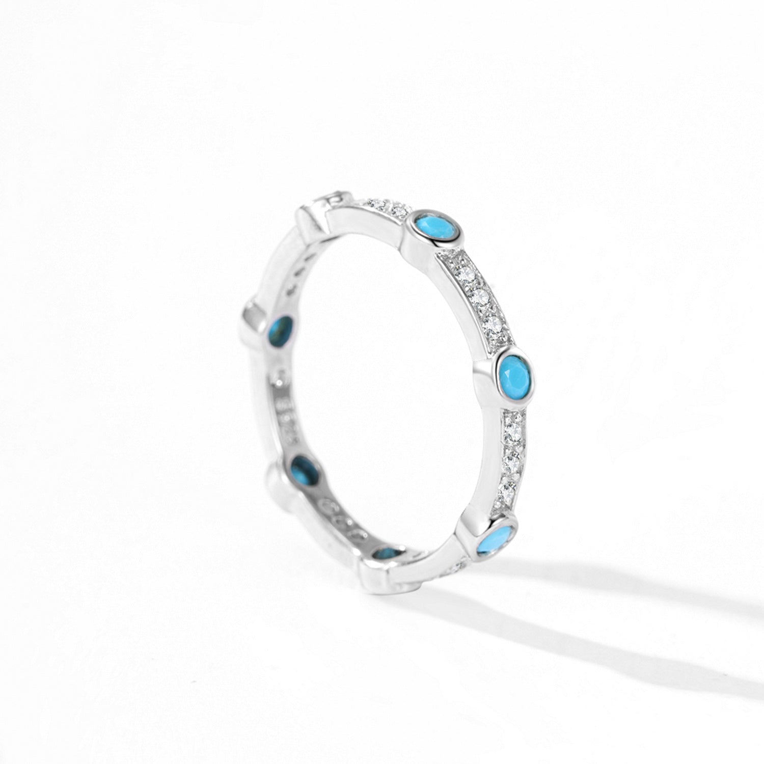 Bague fine en argent sterling sertie de turquoises rondes et de petits cristaux scintillants, motif répétitif.