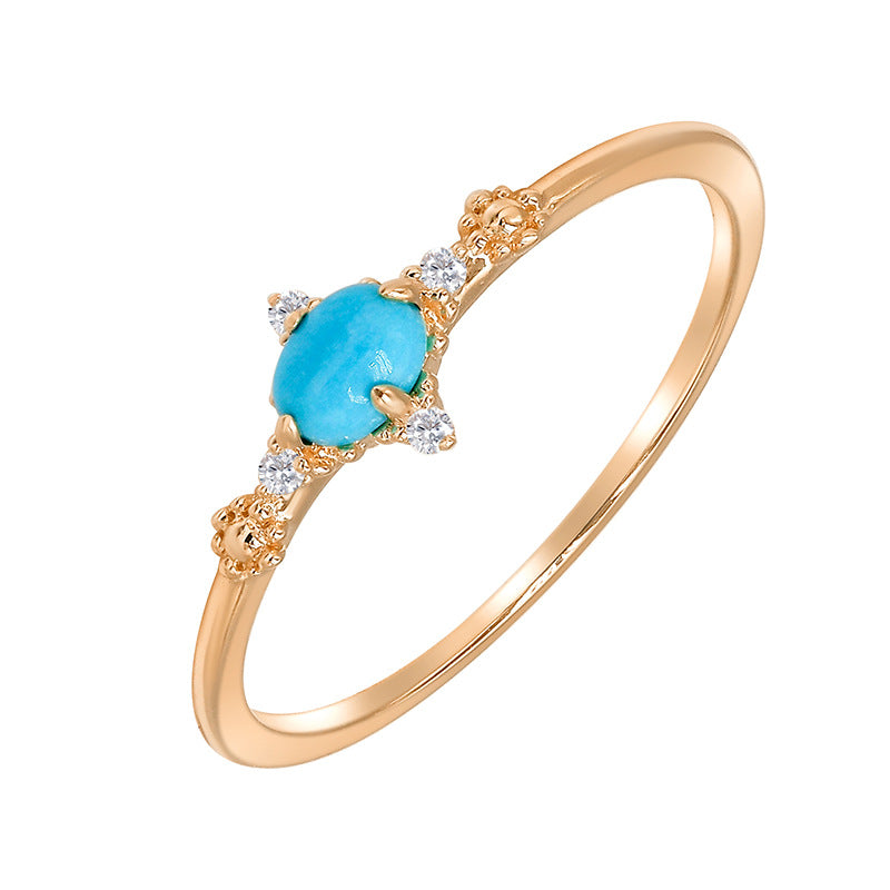 Bague fine en argent plaqué or 14k sertie d'une turquoise ovale bleue et de petits zircons cubiques brillants, avec des détails texturés sur le côté.