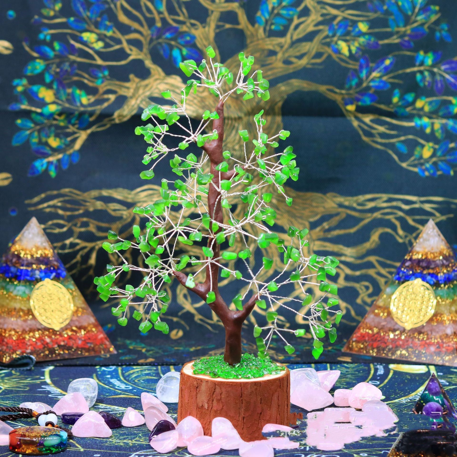 Arbre de Vie en pierres vertes, avec un tronc marron et une base en bois, entouré de pyramides de chakras et de cristaux roses.