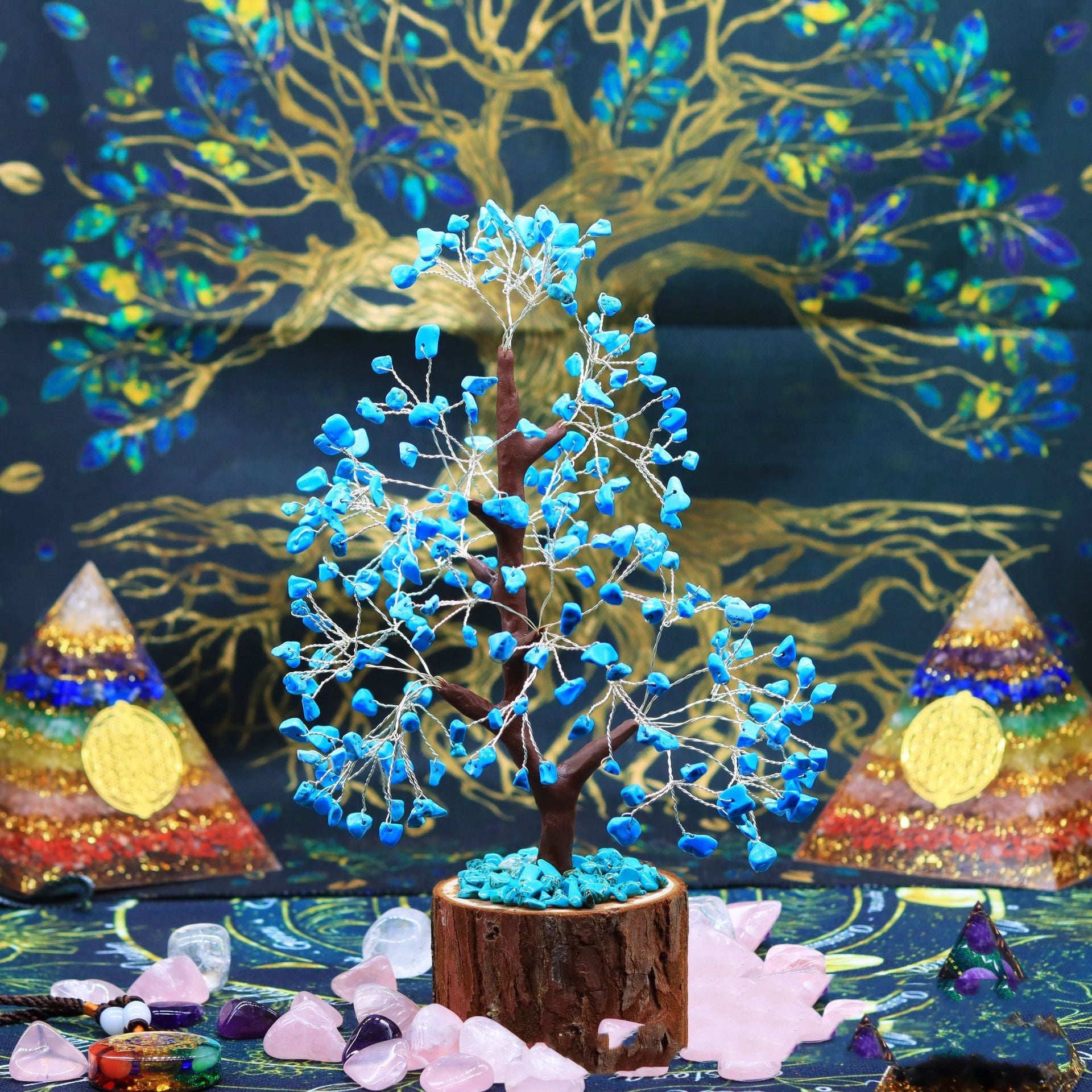 Arbre de Vie Beauté de Nature en pierres bleues et turquoise sur un socle en bois, entouré de cristaux et de pyramides de chakras.