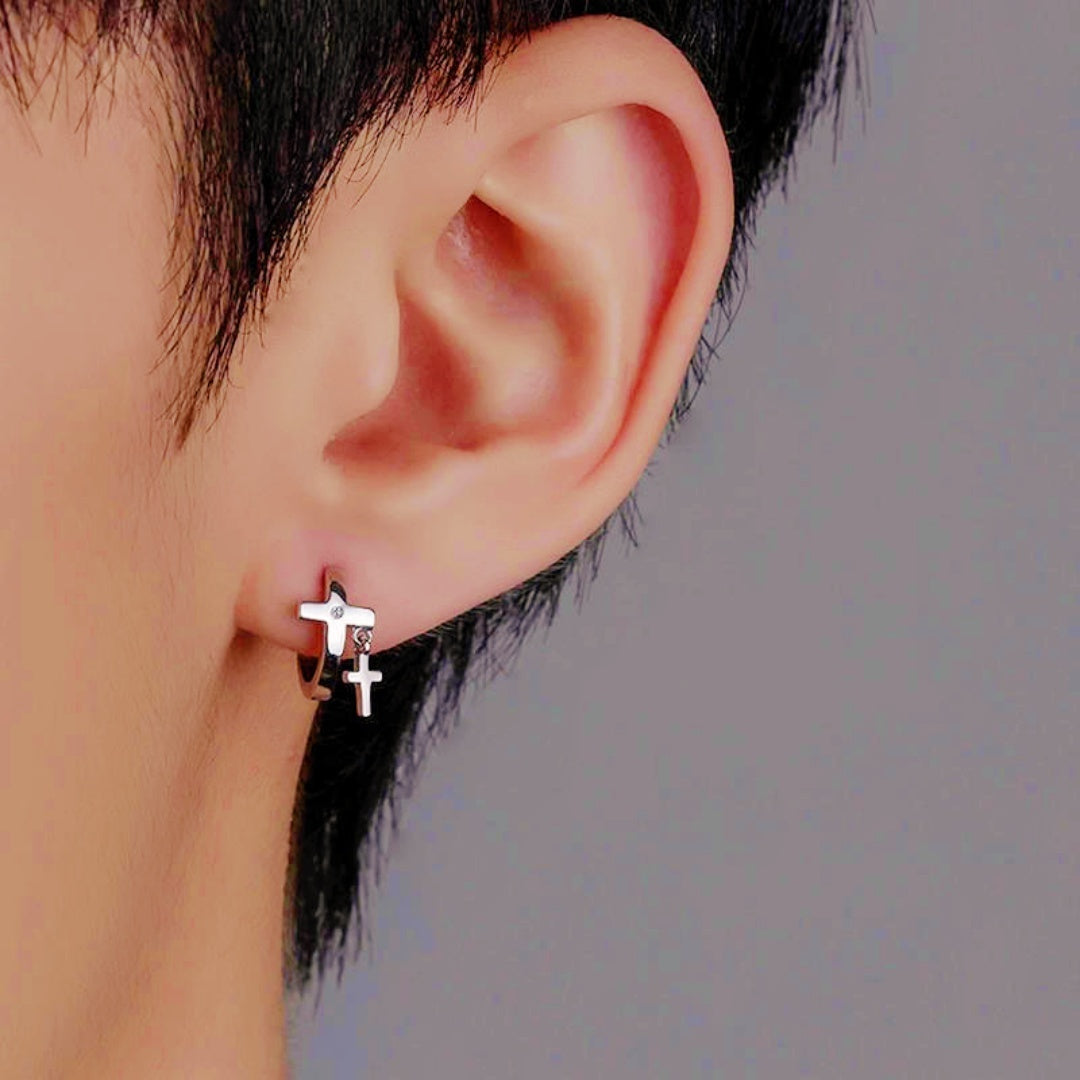 Boucle d'oreille homme argentée avec deux pendentifs croix superposés, dont un orné d'une petite pierre scintillante.