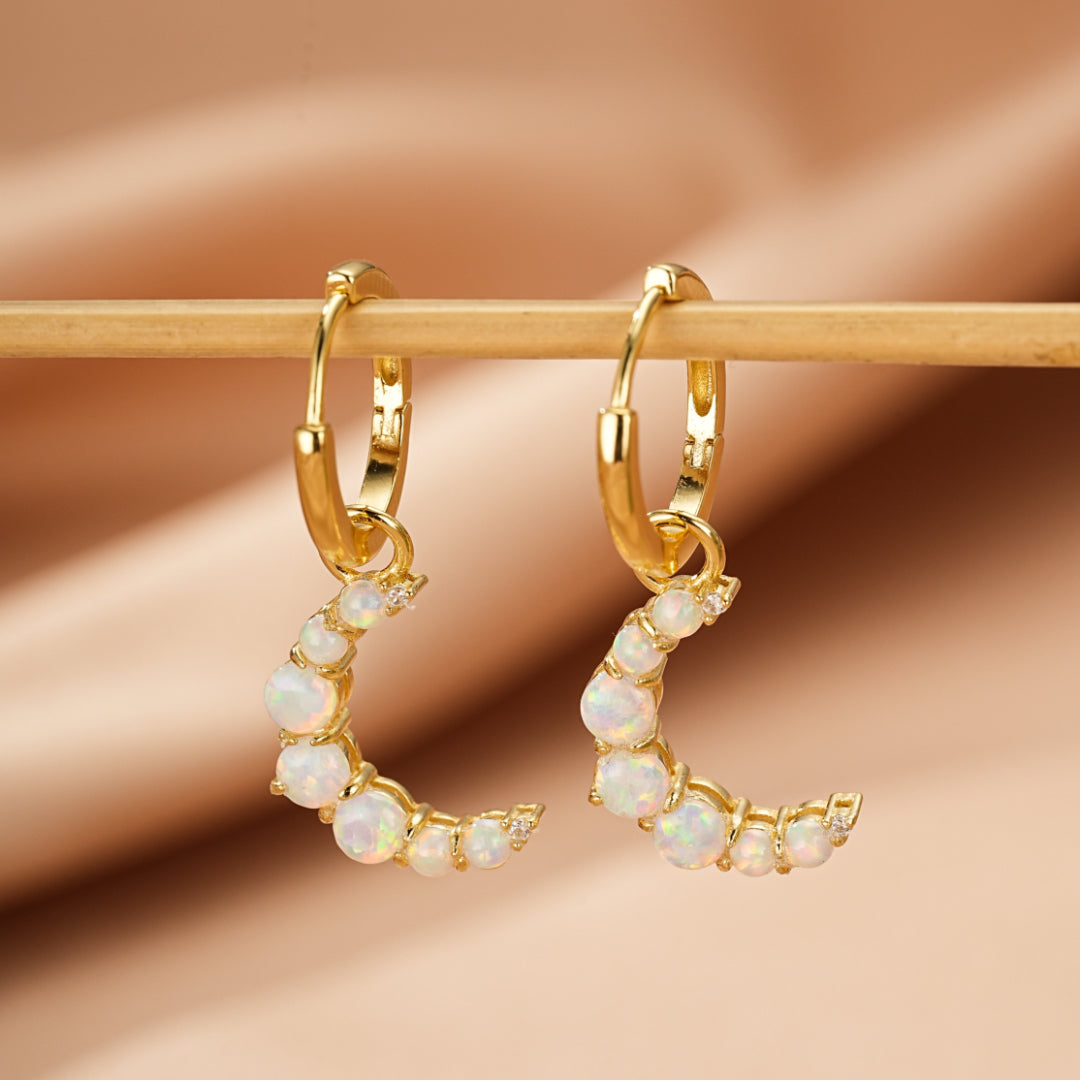 Paire de boucles d'oreilles créoles plaquées or 18K ornées d'opales blanches et de petits diamants sertis en forme de croissant de lune.