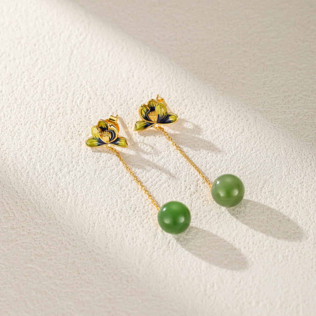Vue rapprochée des boucles d'oreille ethniques en jade et lotus, fabriquées en argent plaqué or. Un accessoire délicat et confortable qui apporte tranquillité et beauté.