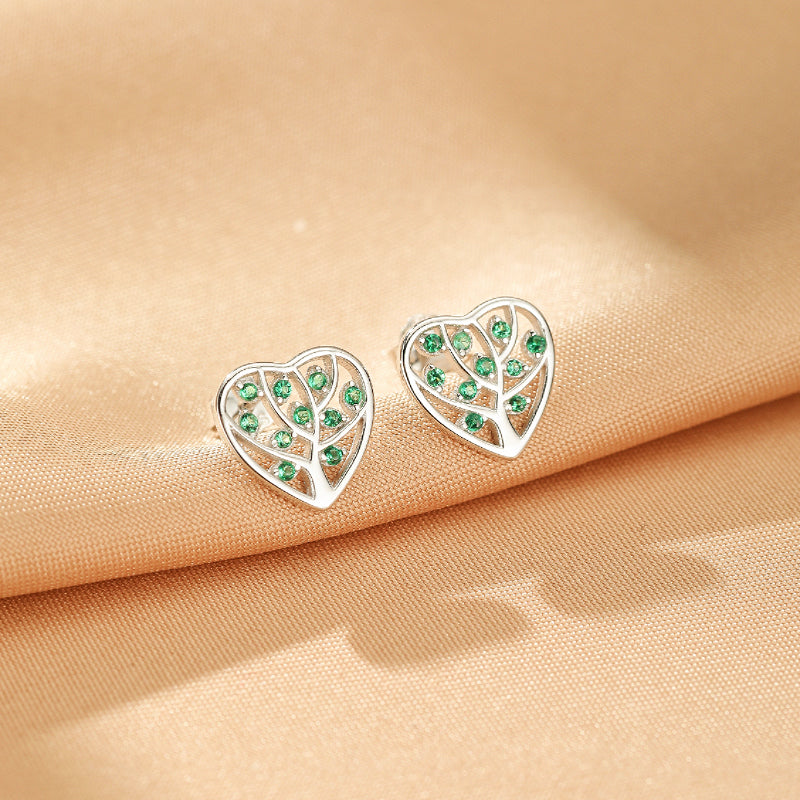 Paires de boucles d'oreilles en forme de cœur en argent 925, ornées d'un motif d'arbre de vie ajouré et de petites pierres vertes scintillantes.