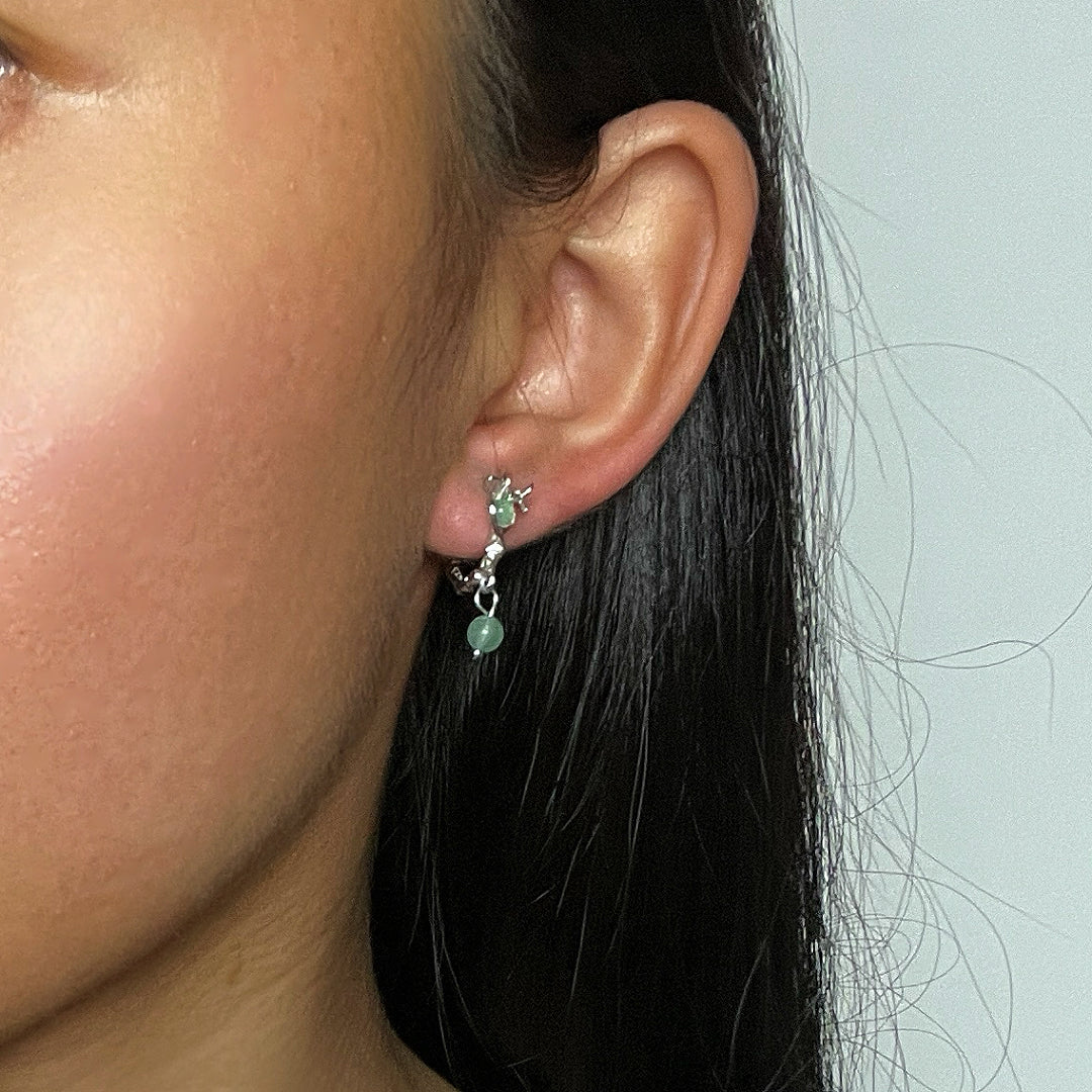Boucles d'oreilles argentées ornées de petites pierres vertes d'aventurine, design inspiré des rameaux.