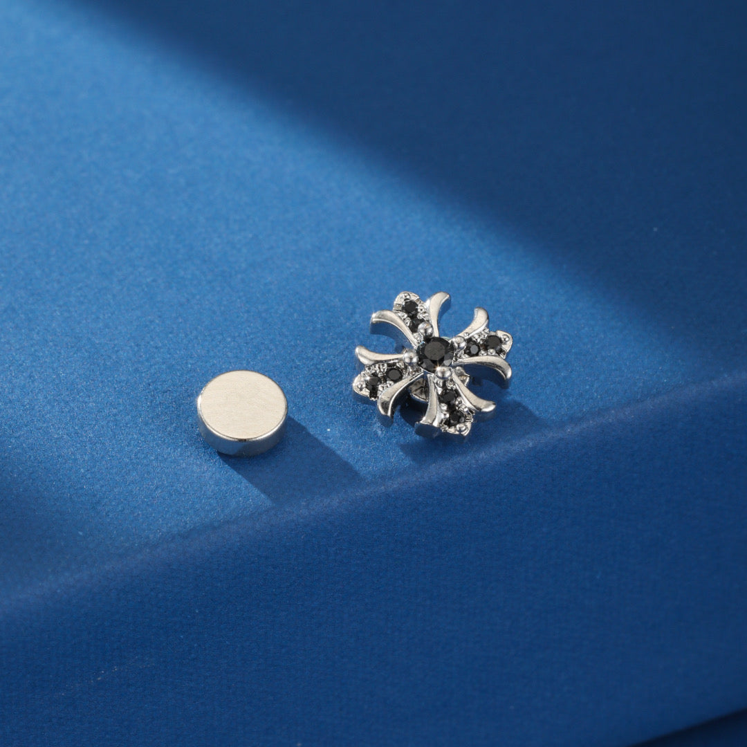 Détail des boucles d'oreilles magnétiques pour homme Éclat Royal, illustrant la forme de croix et la qualité de l'acier.