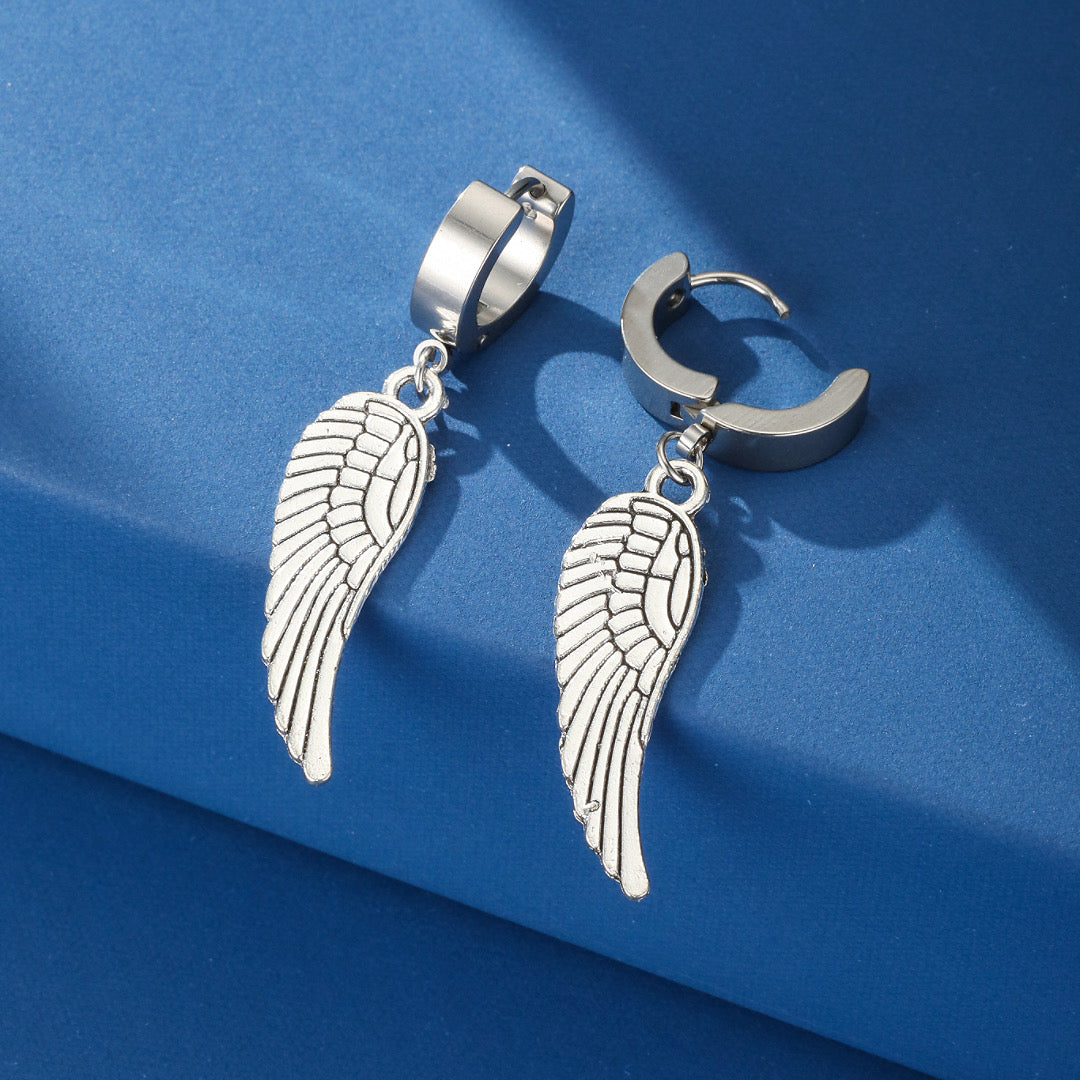Boucles d'oreilles homme argentées avec pendentifs ailes d'ange, style rebelle et audacieux.