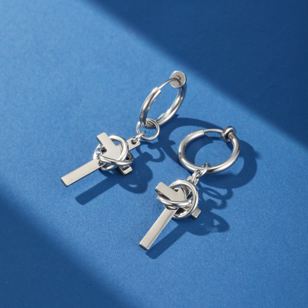 Boucles d’oreilles homme en acier inoxydable avec croix minimaliste et anneau lisse, symbole d'union et d'équilibre.