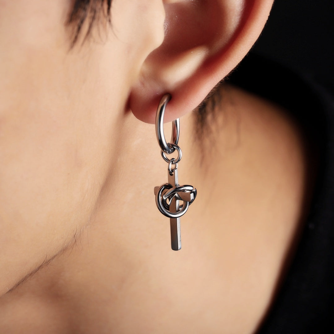Vue de face d'une boucle d'oreille homme en acier inoxydable arborant une croix minimaliste avec un anneau poli.