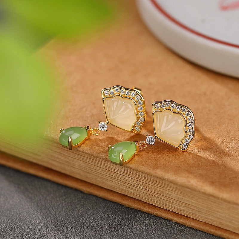 Boucles d'oreilles en argent plaqué or ornées de jade vert et de nacre blanche, serties de petits cristaux brillants, avec un design de éventail élégant.