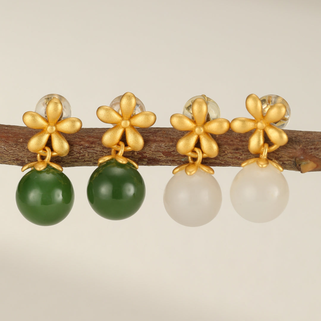 Boucles d’oreilles pendantes en argent plaqué or avec des perles rondes en jade vert et blanc et des motifs de fleurs dorées.
