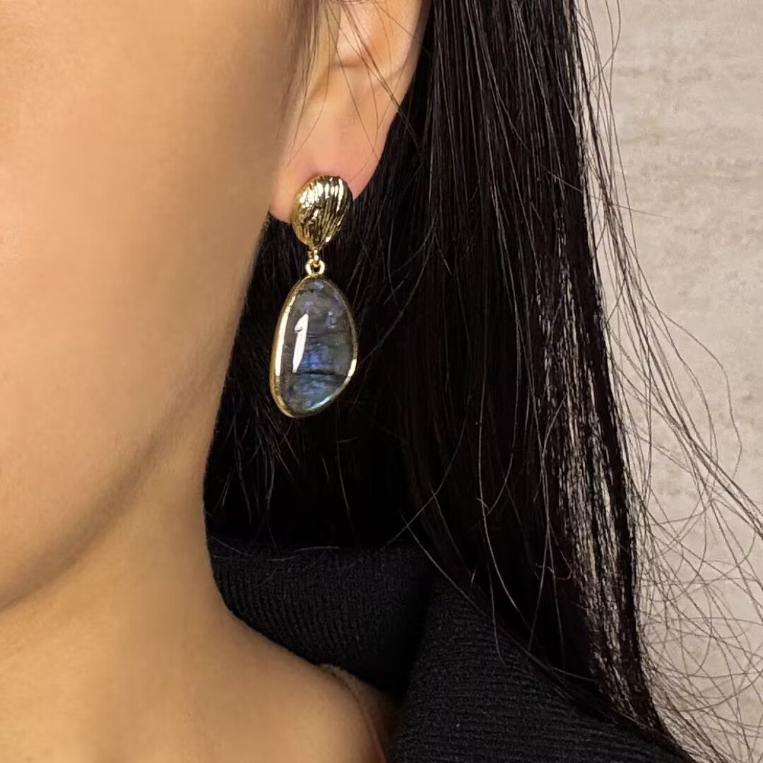 Boucles d'oreilles pendantes en labradorite naturelle avec monture dorée, capturant la lumière pour un éclat unique.