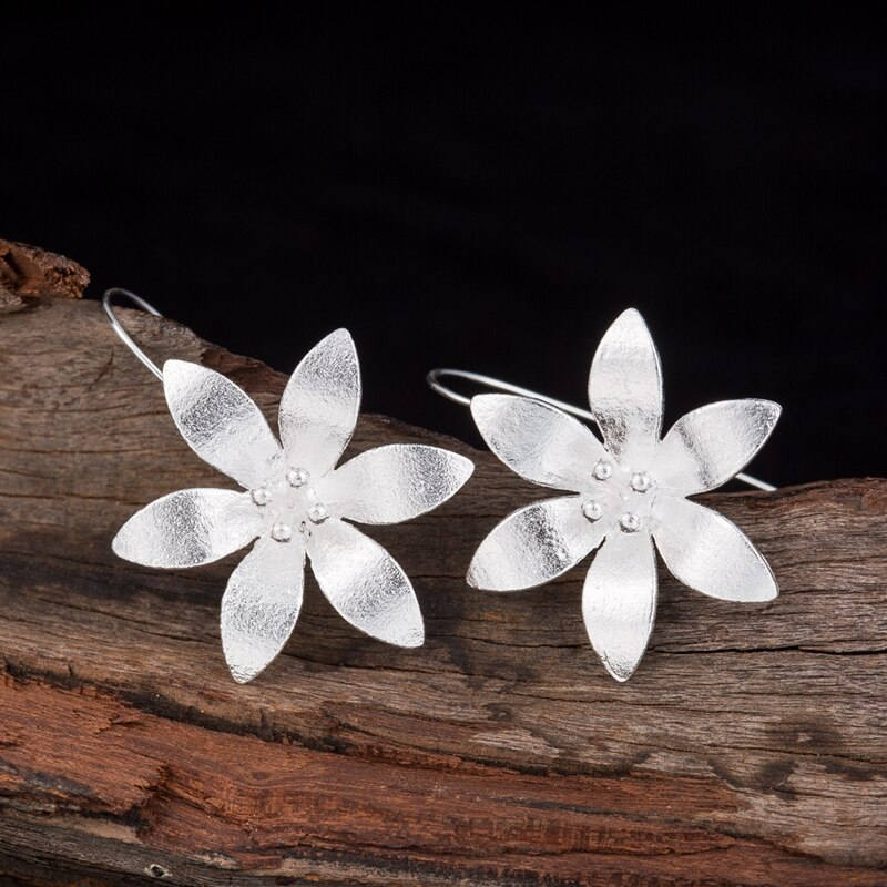 Boucles d'oreilles pendantes en argent, motif fleur de lotus éclose, avec de petits points au centre.