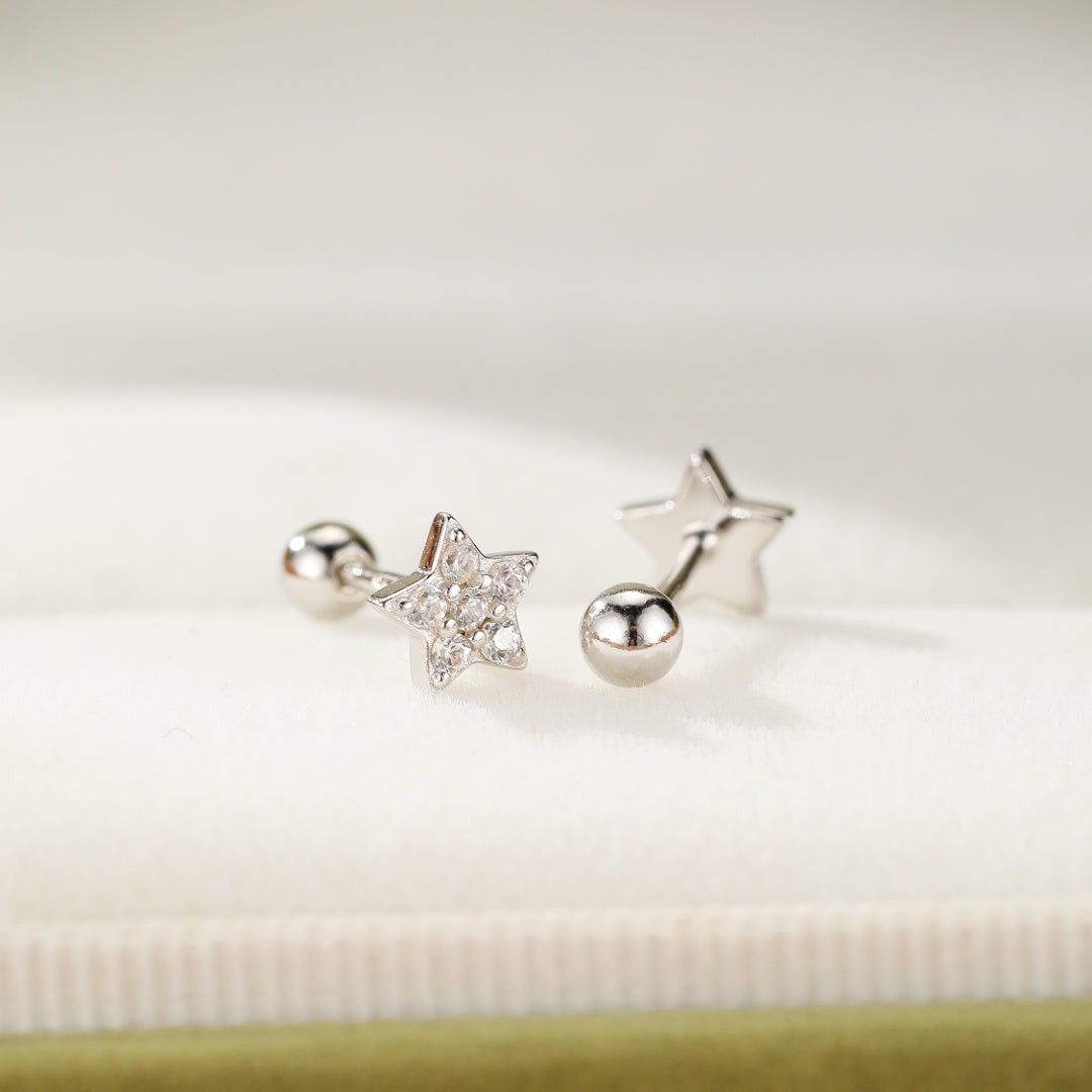 Boucles d'oreilles "Lumière Céleste" en argent 925, l'une sertie de cristaux formant une étoile, l'autre avec une boule polie.