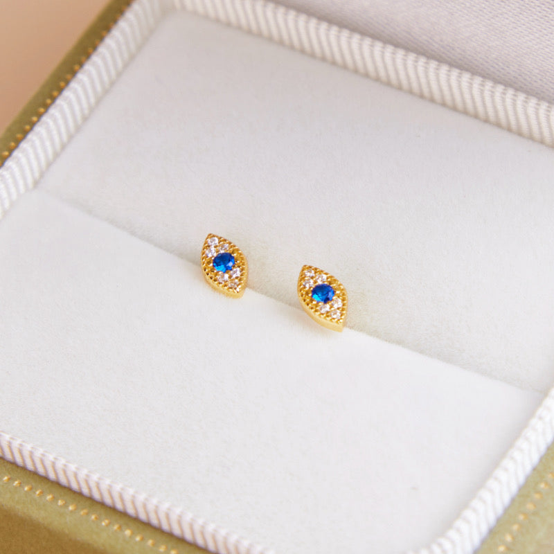 Boucles d'oreilles œil bleu et zircons blancs en forme de losange, plaqué or, présentées dans une boîte cadeau.