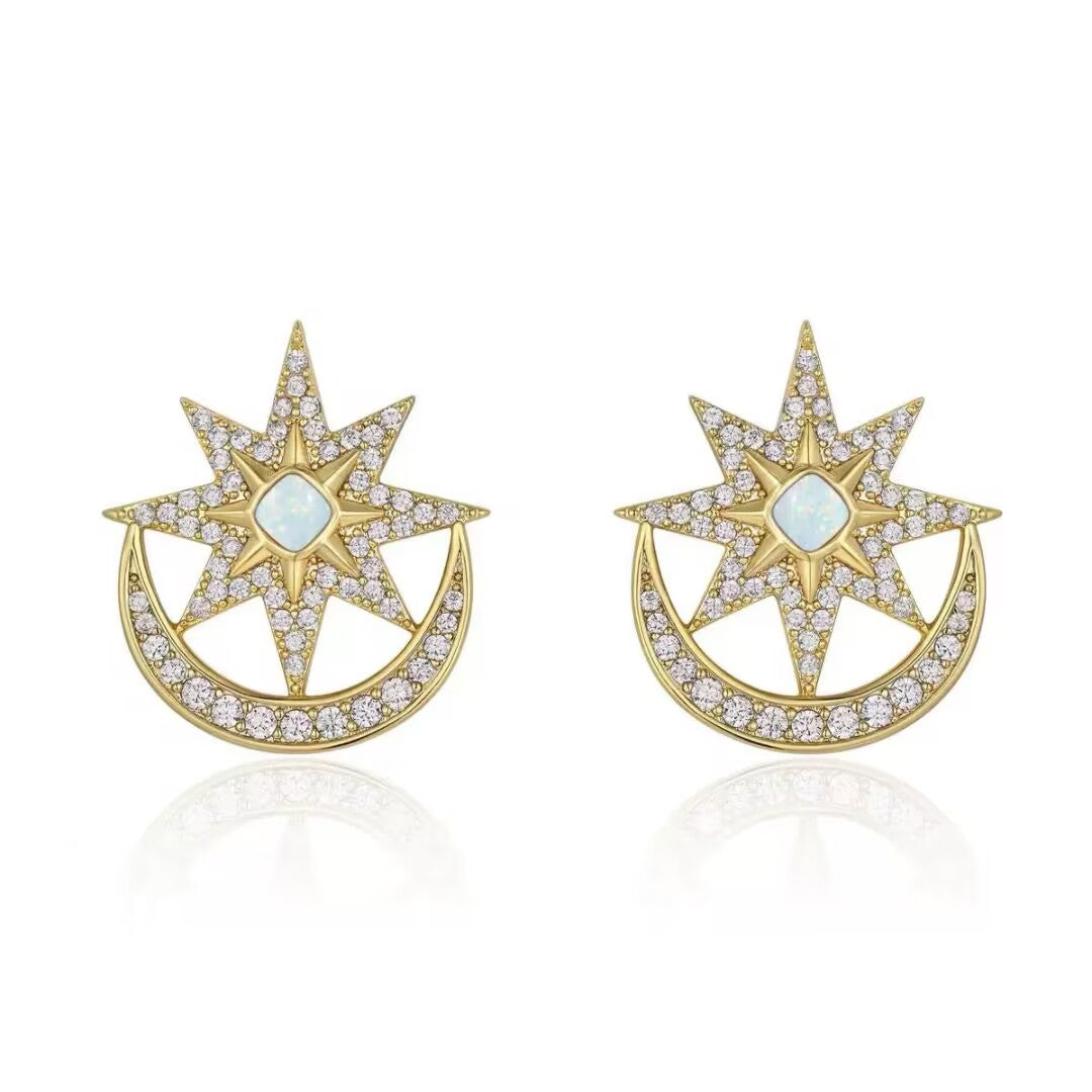 Paire de boucles d'oreilles en or jaune serties d'opale et de zircons blancs, représentant une étoile à huit branches sur un croissant de lune.