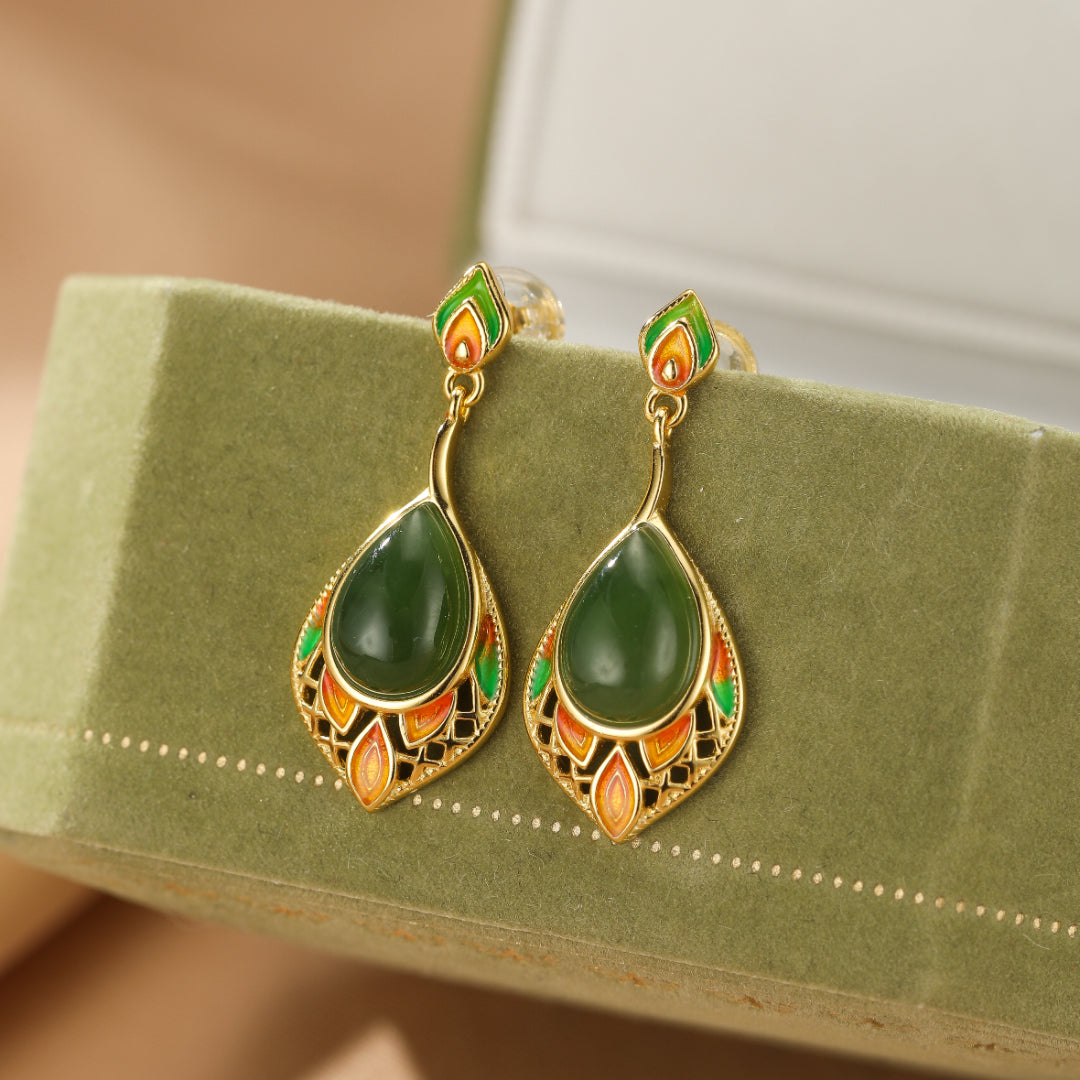 Boucles d'oreilles pendantes en argent plaqué or ornées de jade vert et d'émaux colorés évoquant une feuille.