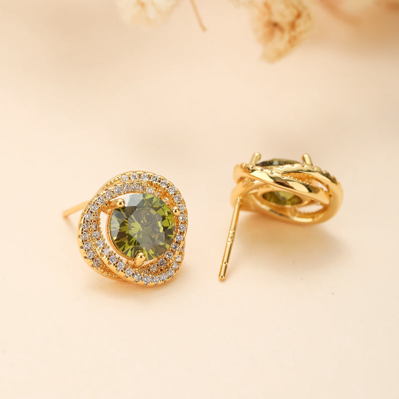 Paire de boucles d'oreilles en argent plaqué or avec une pierre centrale ronde péridot entourée de petites pierres scintillantes et d'un design torsadé.