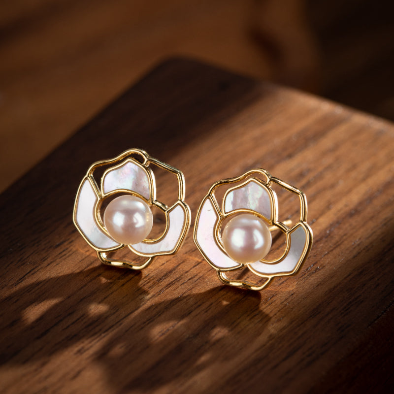 Boucles d'oreilles en forme de fleur avec une perle au centre, montées sur du plaqué or.