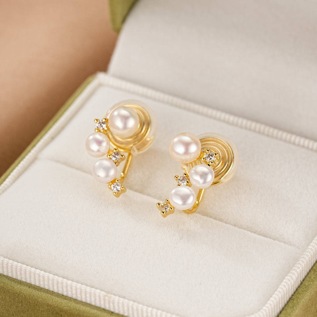 Boucles d'oreilles plaqué or ornées de perles et de zircons cubiques, présentées dans un écrin vert.