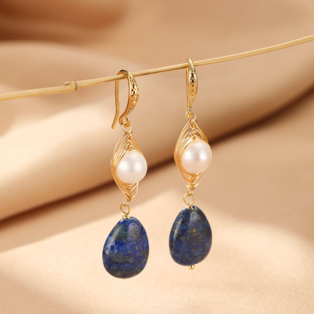Boucles d'oreilles pendantes en or avec perles blanches et pierres de lapis-lazuli bleues en forme de goutte.