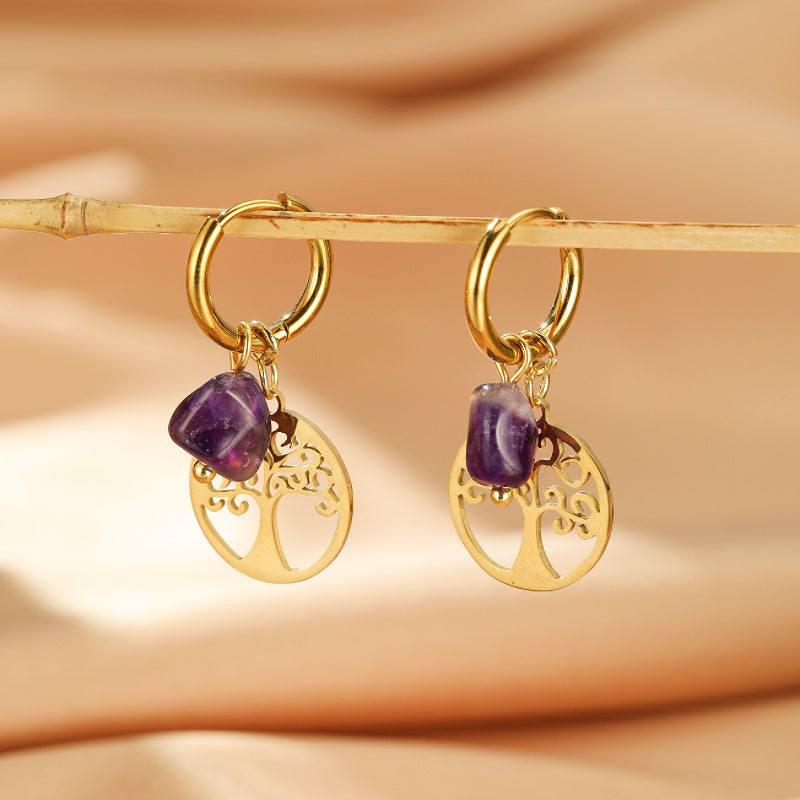 Boucles d'oreilles dorées ornées de pierres naturelles d'améthyste brute et de pendentifs Arbre de Vie ajourés, suspendues à des anneaux.