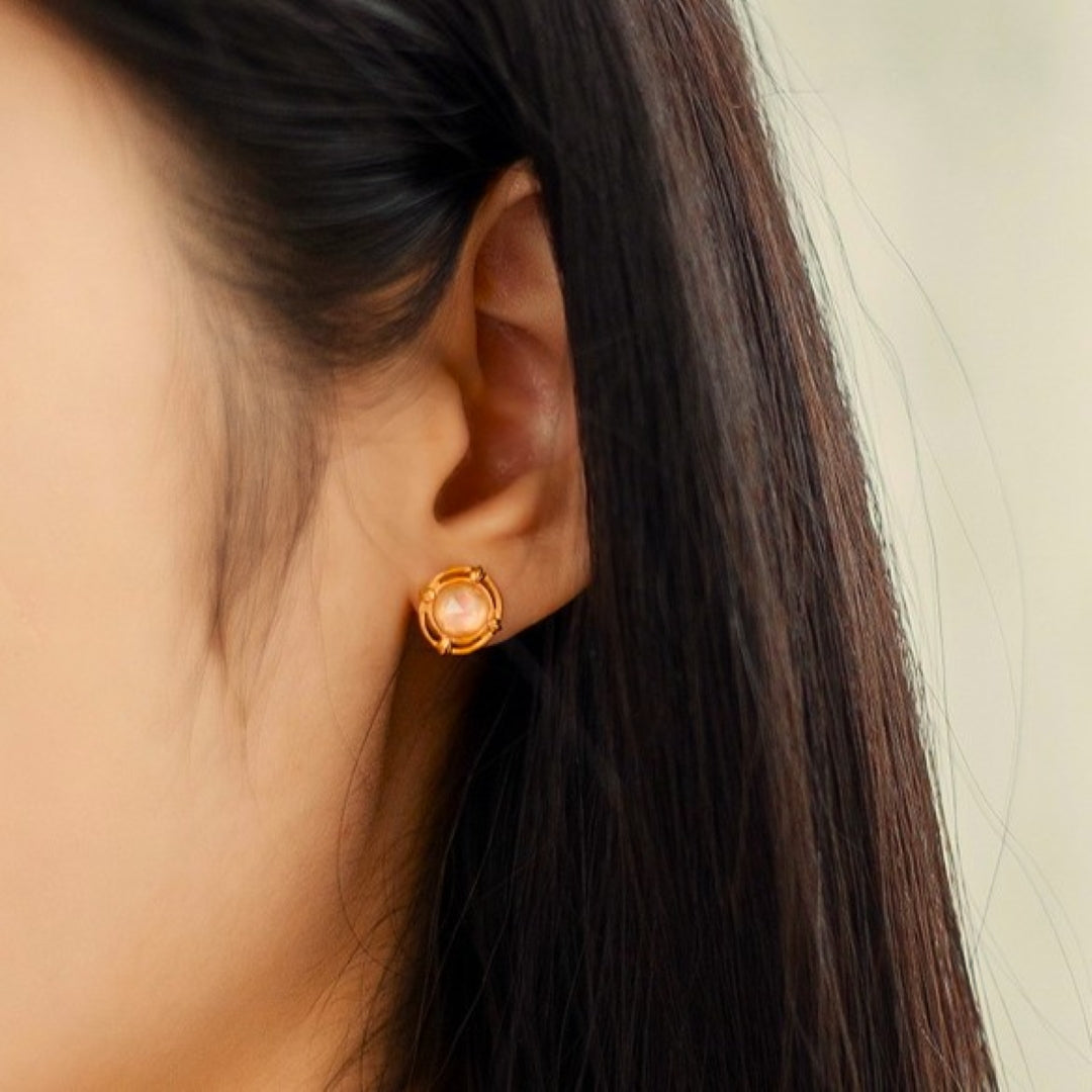 Boucle d'oreille Aura Radieuse en quartz rose et argent plaqué or 10K portée à l'oreille.