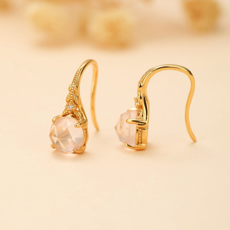 Boucles d'oreilles pendantes en argent plaqué or ornées de quartz rose facetté et de petites pierres scintillantes, style floral.