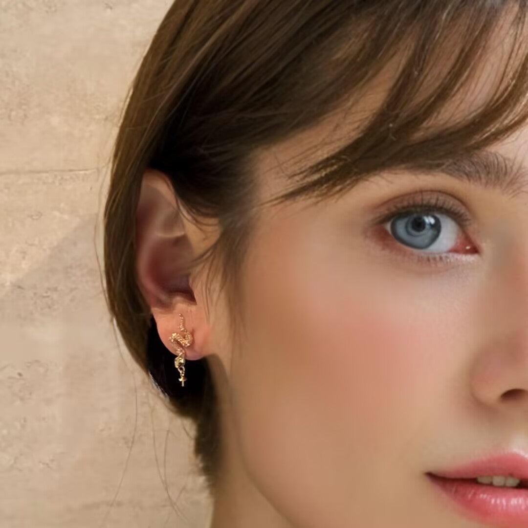 Boucle d'oreille serpent en argent 925, modèle Danse Abyssale, portée par une femme avec des yeux bleus perçants