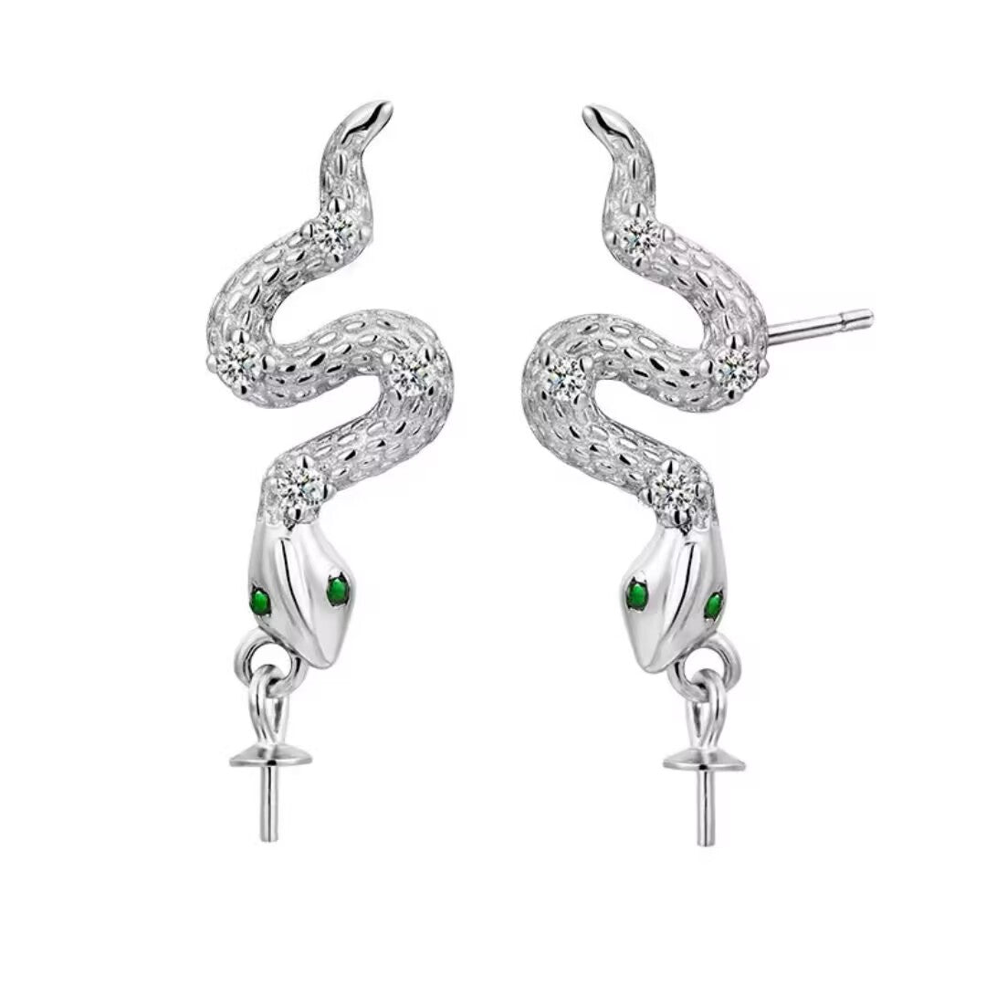 Paire de boucles d'oreilles en argent 925 représentant des serpents stylisés avec des yeux verts et des zircons incrustés, un design unique pour un look audacieux.