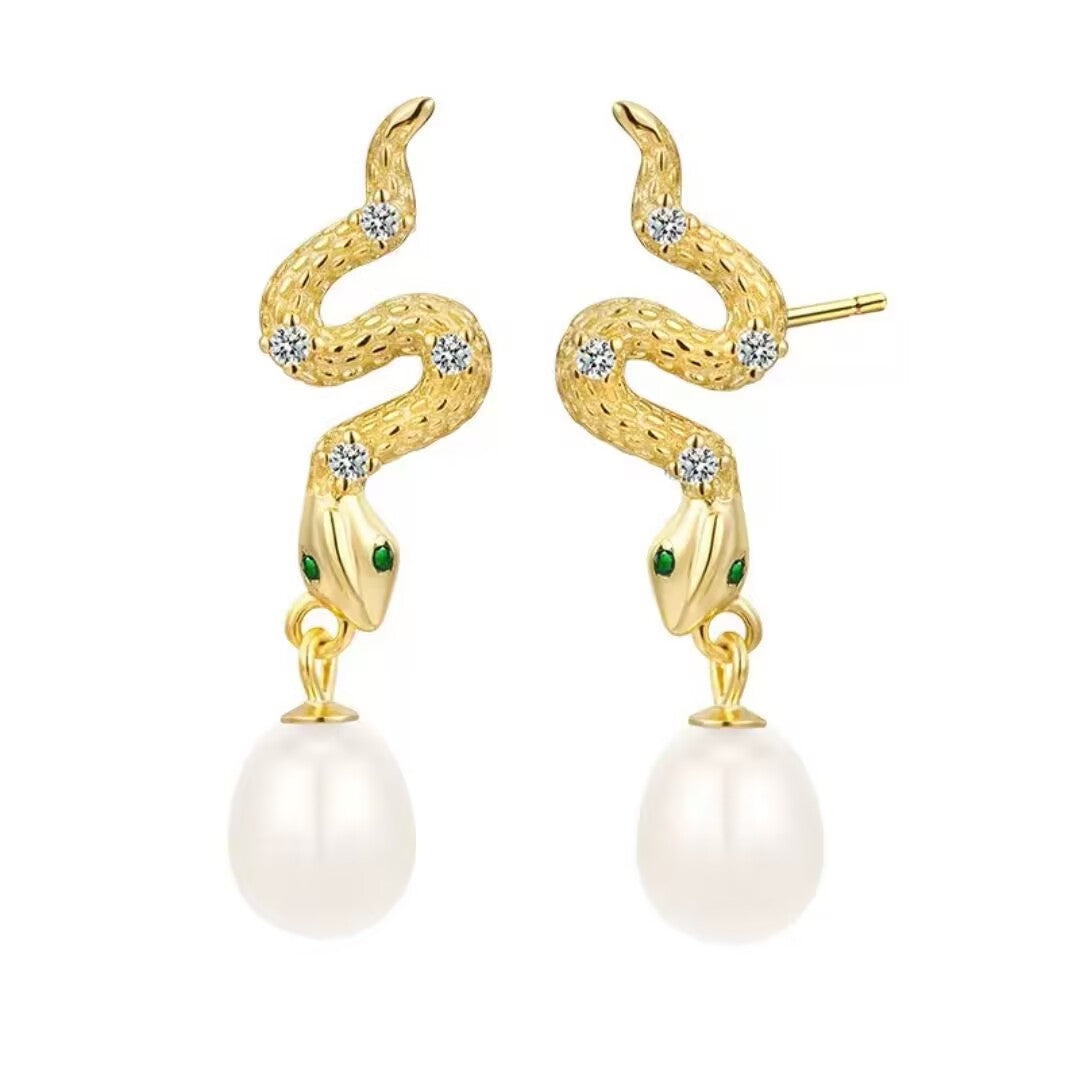 Paire de boucles d'oreilles serpent dorées ornées de zircons et de perles blanches pendantes, avec des yeux en émeraude.