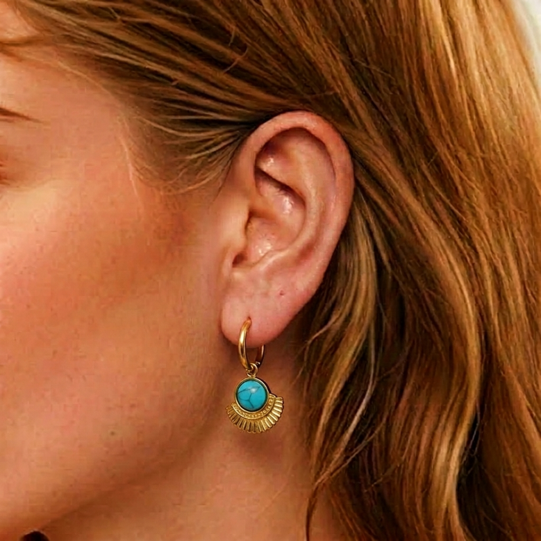 Boucle d'oreille dorée avec une turquoise ronde sertie sur un pendentif en éventail doré nervuré.