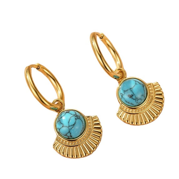 Boucles d'oreilles créoles dorées ornées d'une turquoise ronde et d'un pendentif ajouré en éventail gravé dans un style bohème chic.