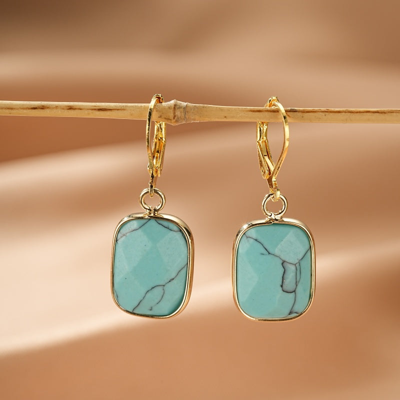 Boucles d'oreilles pendantes dorées avec une pierre turquoise carrée aux veines noires, style Nébuleuse d’Azur.
