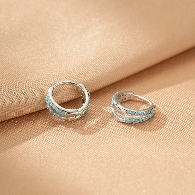 Boucles d'oreilles créoles argentées ornées de deux rangées de petites pierres turquoise bleues, style antique.